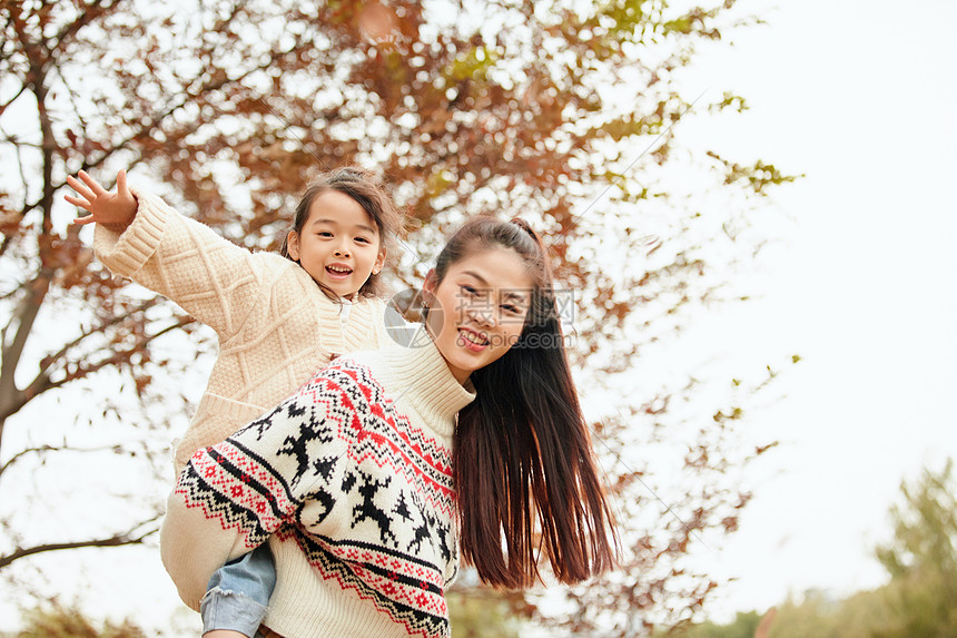 年轻妈妈背着女儿玩耍图片