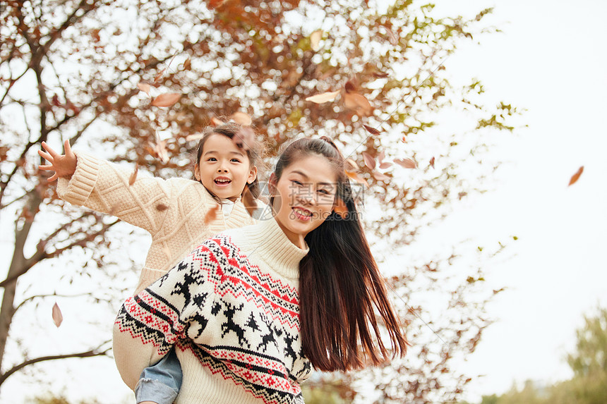 年轻妈妈背着女儿玩耍图片