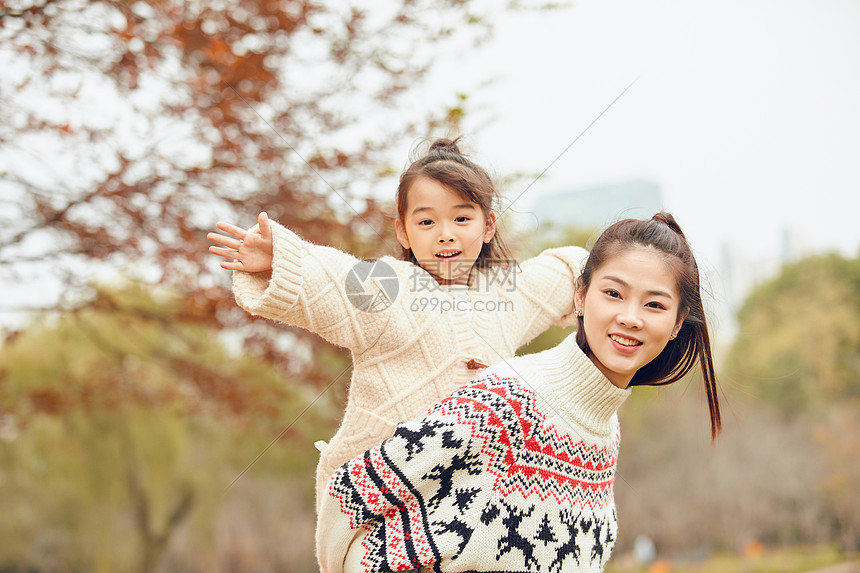 年轻妈妈背着女儿玩耍图片