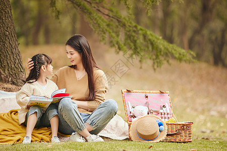 户外野餐温馨母女在树下看书背景