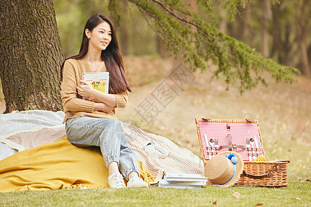 户外野餐年轻女性树下看书背景