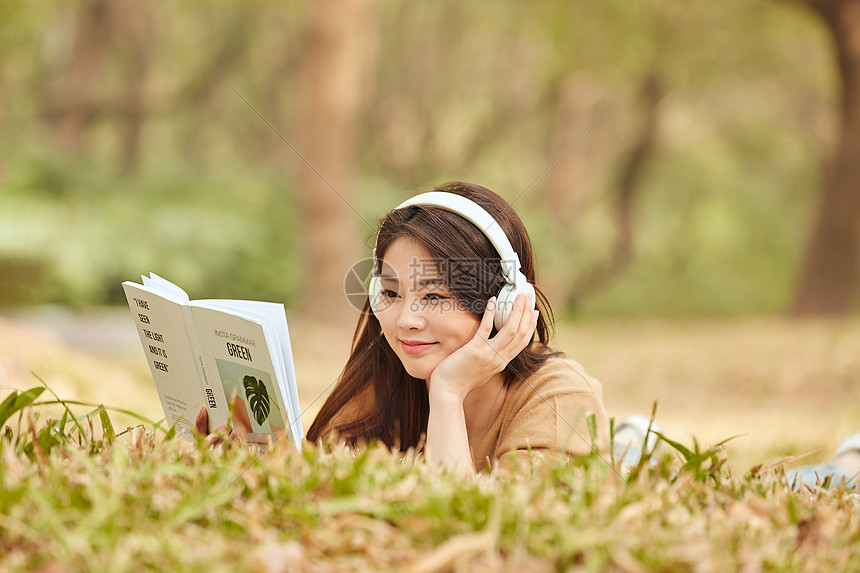 年轻女性户外听音乐看书图片