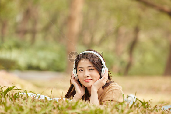 年轻女性户外听音乐看书图片