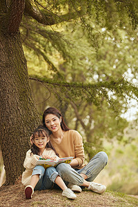 温馨母女坐在树下读书图片