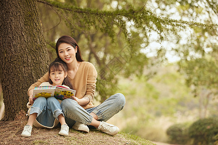 温馨母女坐在树下读书图片