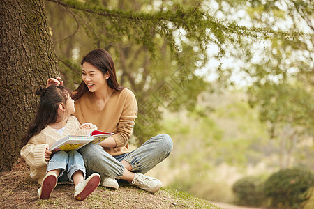 温馨母女坐在树下读书图片