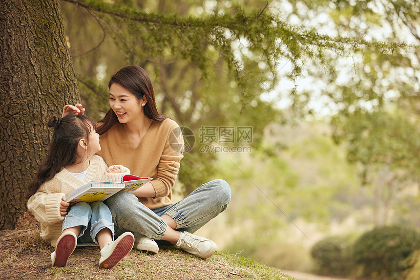 温馨母女坐在树下读书图片