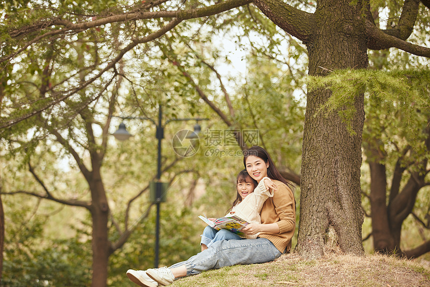 温馨母女坐在树下读书图片