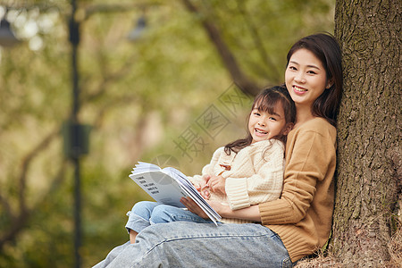 温馨母女坐在树下读书图片