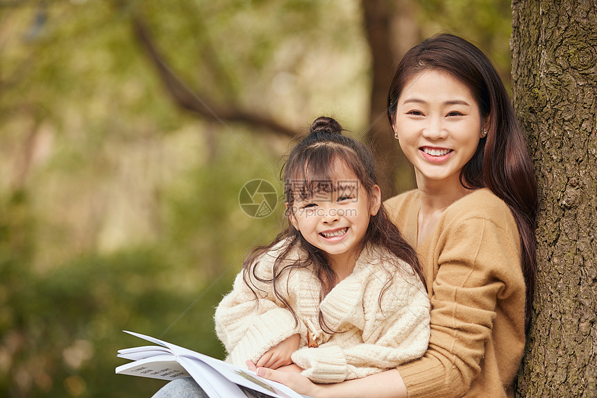 温馨母女坐在树下读书图片