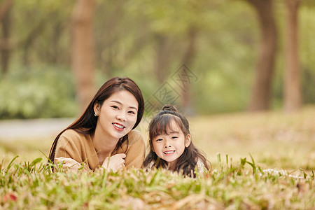 温馨母女趴在草地上玩耍高清图片