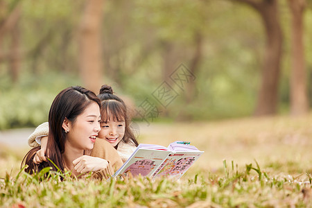 母女趴在草地上读书图片