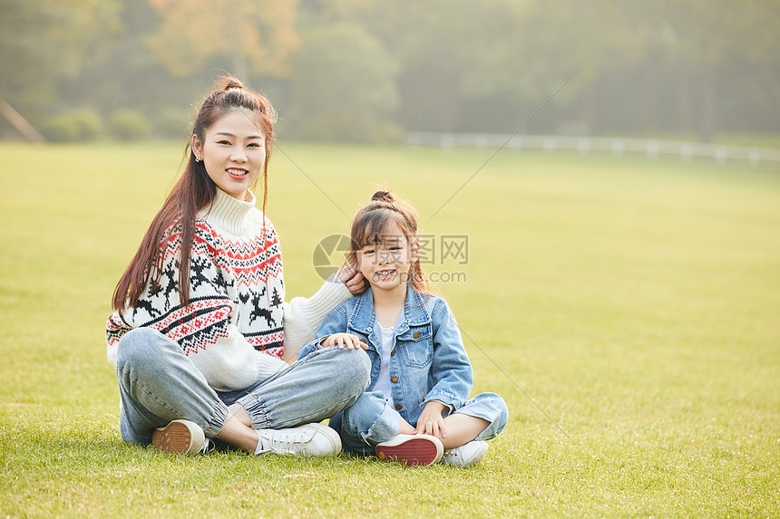 温馨母女坐在草坪玩耍图片