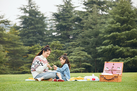 母女坐在草地上玩游戏高清图片