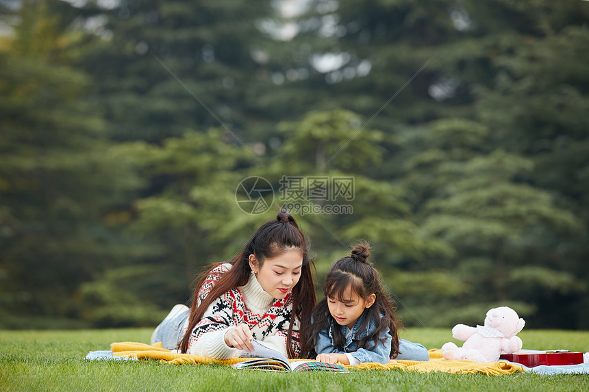 母女趴在草地上阅读图片