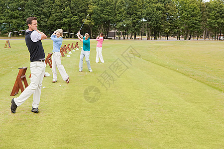 四个高尔夫球手在练习场上图片素材