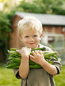 抱着花园农产品的小男孩图片