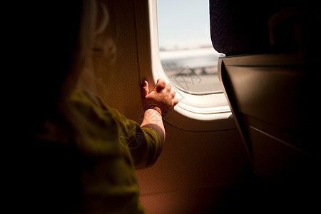从飞机窗户往外看的小男孩图片