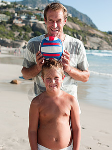 爸爸和儿子在沙滩上玩球图片