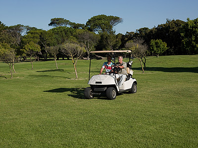两个成熟的男子在高尔夫球场的高尔夫球车上图片