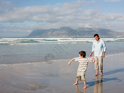 父子俩在海里扔石头图片