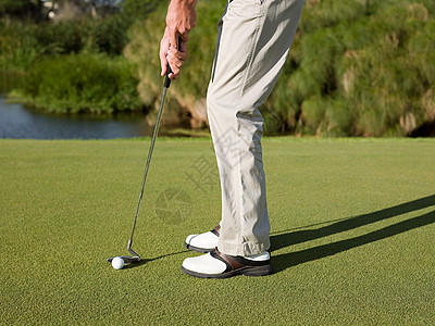 在高尔夫球场上打高尔夫的人背景图片