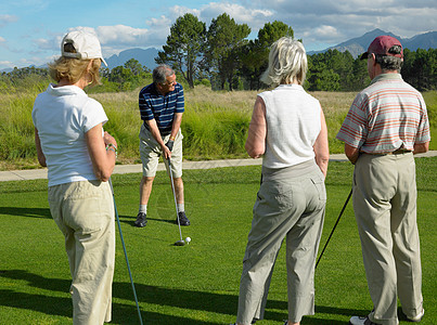 女人打高尔夫中老年人在公园打高尔夫球背景