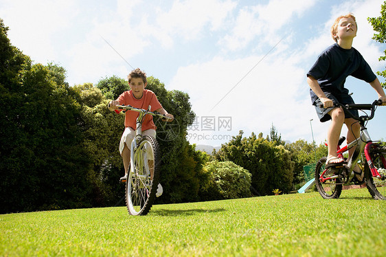 年轻男孩在公园骑自行车图片