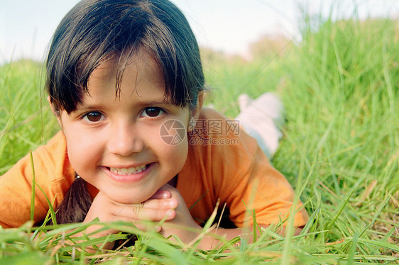 微笑的女孩躺在草地上图片