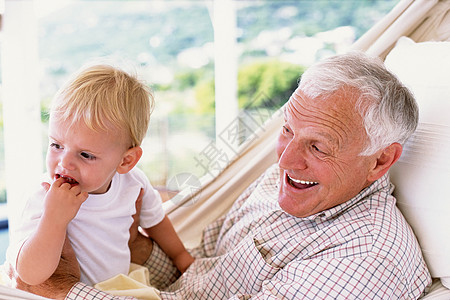 老人带孩子爷爷和孙子在吊床上玩背景