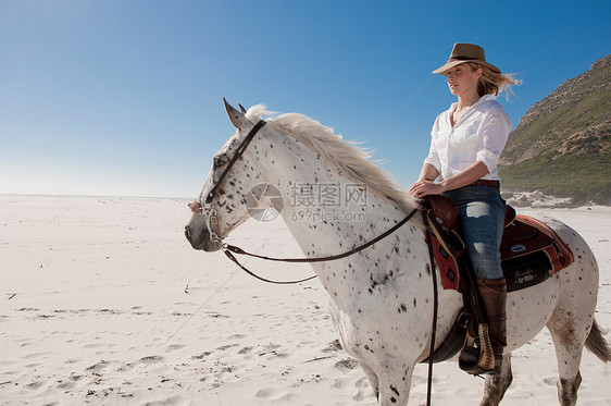 在海滩上骑马的人图片