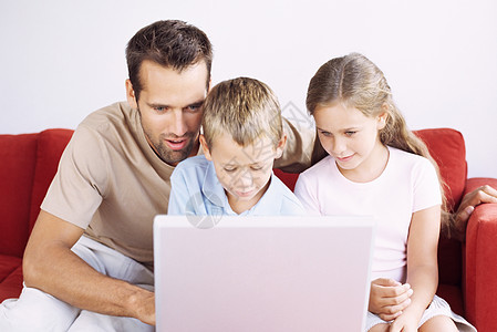 父亲和孩子使用笔记本电脑图片