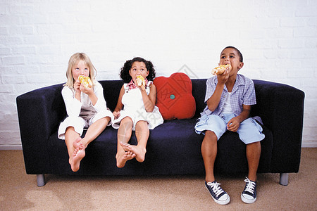 男孩和女孩在沙发上吃饭图片