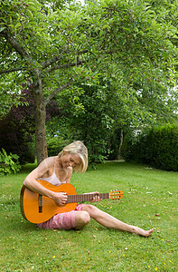 在花园里弹吉他的女人图片