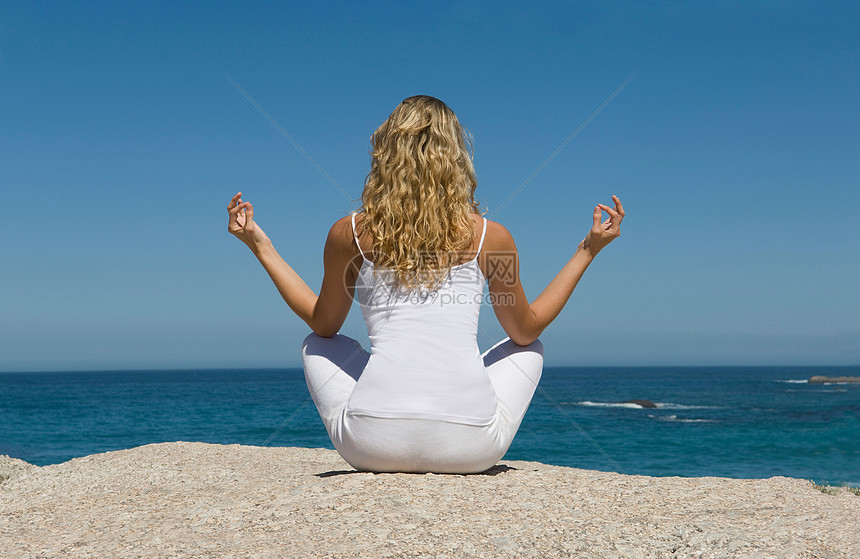 女人坐在海海滩上图片