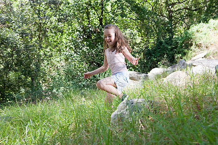 女孩在草地上跳跃图片
