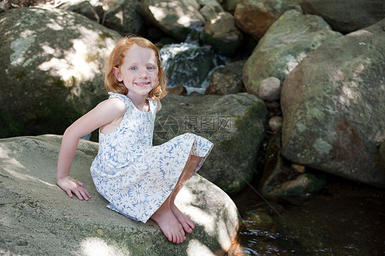 在河边岩石上的女孩图片