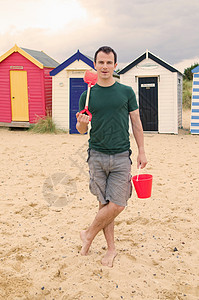 海滩上玩沙的男人图片