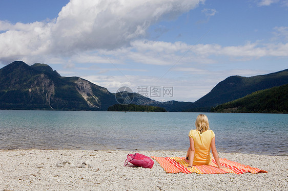 躺在沙滩巾上放松的女孩图片