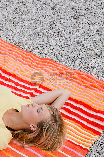 躺在沙滩巾上放松的女孩图片