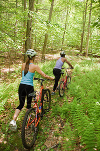 在森林里骑车的两个女自行车手图片
