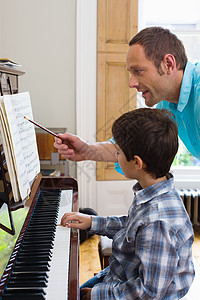 弹钢琴男孩父亲教儿子弹钢琴背景