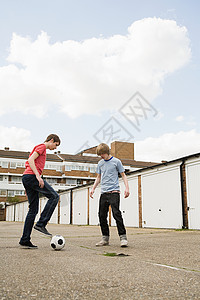 十几岁的男孩在踢足球背景图片