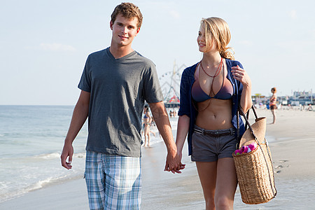夫妇在海滩上手挽手散步图片