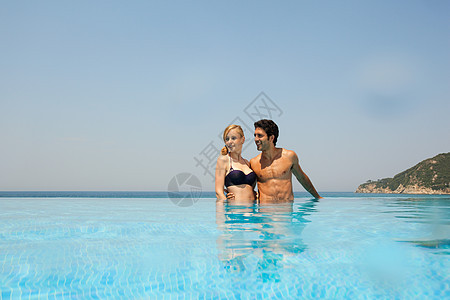 无边泳池中的年轻夫妇图片