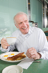 老人在吃油炸早餐图片