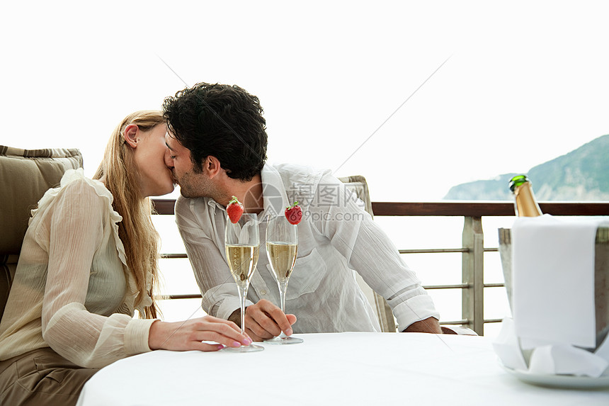 年轻夫妇喝香槟接吻图片