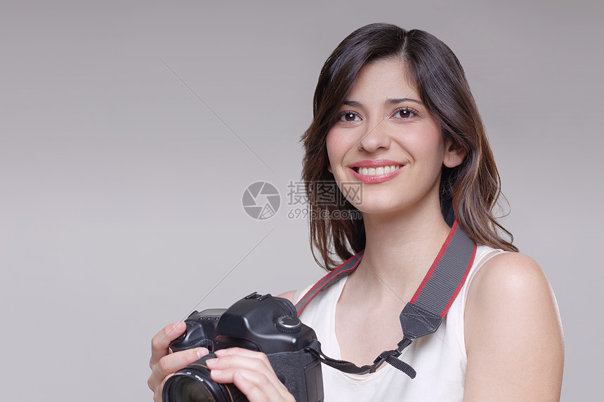 拿着数码单反相机的年轻女子图片