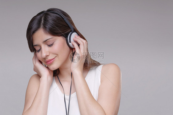 戴着耳机听音乐的年轻女子图片