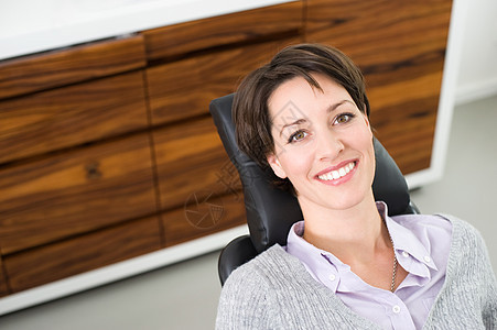 坐在牙医椅子上的女人图片
